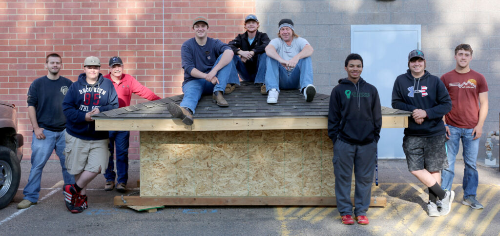 Students with finished roofing project