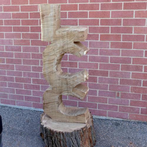 Carpentry cuts an "LCC" from a log using a chainsaw